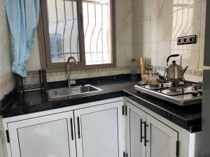 une cuisine avec un évier et une cuisinière dans l'établissement Sunset house, à Taghazout 14 autres photos