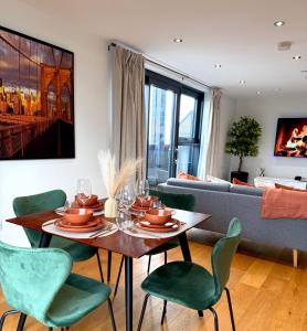ein Wohnzimmer mit Tisch und Stühlen und einer Couch in der Unterkunft Luxe Duplex Penthouse Stay in Leeds Centre - Free Parking in Leeds