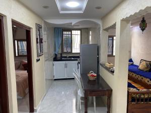 - une cuisine avec une table et un réfrigérateur dans la chambre dans l'établissement Sunset house, à Taghazout