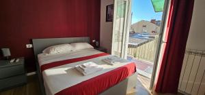 mała sypialnia z łóżkiem i widokiem na balkon w obiekcie Orienty Home Pentacoro w Trieście