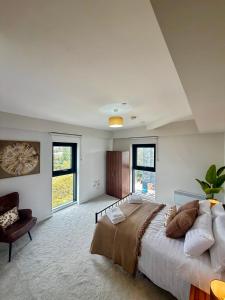 ein großes Schlafzimmer mit einem großen Bett und einem Stuhl in der Unterkunft Luxe Duplex Penthouse Stay in Leeds Centre - Free Parking in Leeds