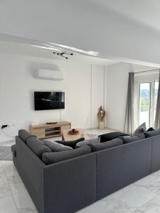 a living room with a couch and a tv at Casa Platania in Eleoúsa