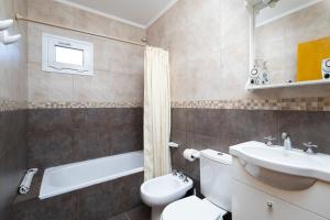 une salle de bain avec des toilettes blanches et un lavabo dans l'établissement Complejo Turistico Paralelo 42, à Lago Puelo