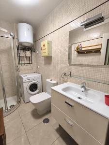 y baño con lavamanos y lavadora. en Parque Royal 1 Apartamento Costa Adeje, en Adeje