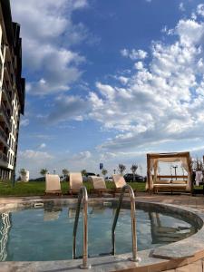 a swimming pool with lounge chairs and a table at UN lux - Residence Hill in Kopaonik