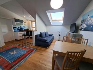 a living room with a table and a blue couch at Apartment Niesenpoint in Albersdorf