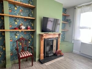 Una sala de estar con televisión y chimenea. en Hartoft House, 3 Bed, Near River and City, en York