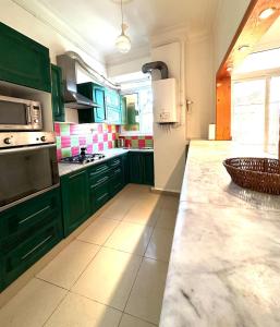 a kitchen with green cabinets and a counter top at Elite location in LʼAgha
