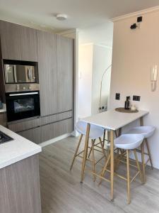 a kitchen with a table and stools in a room at Moderno depa con vista al mar Playa El Laucho in Arica