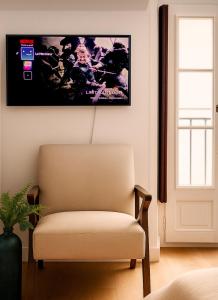 a chair in a room with a picture on the wall at Le Mercœur, appartement calme en hypercentre in Nantes