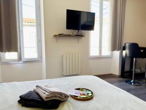 Habitación con cama y bandeja de toallas. en Le Simplicity, en Cognac