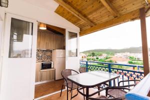a balcony with a table and chairs and a kitchen at Ionio Gastronomy Suites in Ammoudia