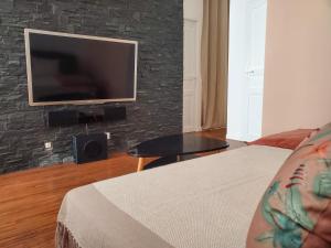 a bedroom with a tv on a brick wall at Appartement lumineux à deux pas du port, avec terrasse in La Ciotat
