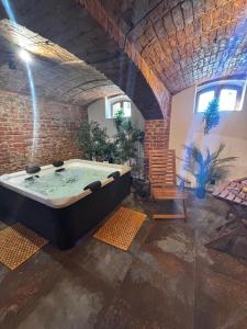 a hot tub in a room with a brick wall at Osada Narost 37 in Chojna
