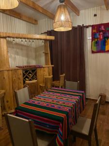 a dining room with a table with a colorful table cloth at Inti Wasi habitaciones in San Pedro de Atacama