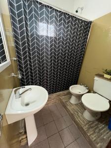 a bathroom with a sink and a toilet at La casita the Aye in Villa Carlos Paz