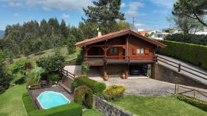 ein Haus mit einem Swimmingpool im Hof in der Unterkunft Chalé do Pinheiro in Vila Nova de Cerveira