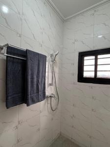 a bathroom with a shower and two black towels at Résidence Eden in Yaoundé +59 photos