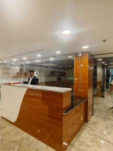 a man in a suit sitting at a bar at Royal Raven Hotel & Banquet' Greater Noida in Greater Noida