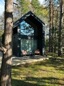 a cabin in the woods with two chairs in it at Bird nest in Undva
