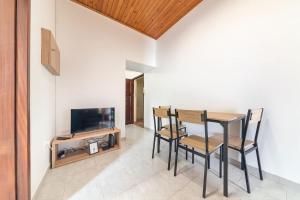 a dining room with a table and chairs and a tv at João Loft Ii by Mth in Campanário