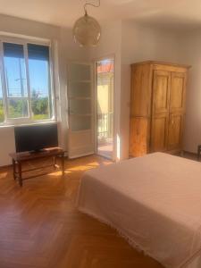 a bedroom with a bed and a flat screen tv at Casa Terrazzino - 50 m dal mare in Bordighera +21 photos