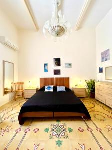 a bedroom with a large bed and a chandelier at Villetta Dorata - Gozo Holiday Home with Terrace & Field View in Qala