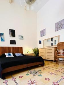 a bedroom with a bed and a dresser and a chair at Villetta Dorata - Gozo Holiday Home with Terrace & Field View in Qala