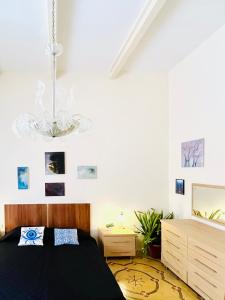 a bedroom with a black bed and a chandelier at Villetta Dorata - Gozo Holiday Home with Terrace & Field View in Qala +20 photos