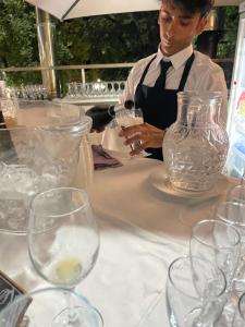 a man is sitting at a table with glasses at Coco Noir Luxury Villa in Trecastagni