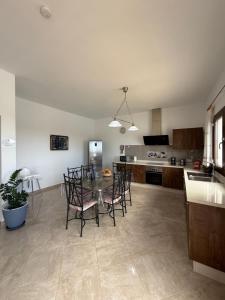 a kitchen with a table and chairs in a room at Villa la Hoya con piscina privada in Las Breñas