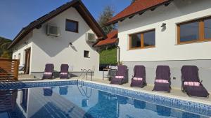 a group of chairs sitting next to a swimming pool at Sunčev breg in Tuheljske Toplice