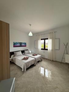 a white bedroom with two beds and a window at Villa la Hoya con piscina privada in Las Breñas +15 photos
