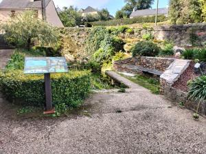 a sign in front of a garden with a bench at Escapade nature à Langon logement rénové in Langon