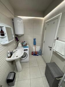 a small bathroom with a toilet and a sink at The Urban Nest Central Skopje Cozy 2BR Ap in Skopje +39 photos