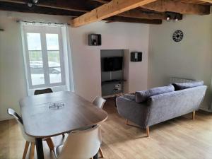 a living room with a table and a couch at Escapade nature à Langon logement rénové in Langon
