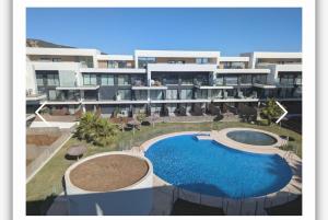 un grand immeuble d'appartements avec une grande piscine dans l'établissement Casa Bakara la Brisa Zahara beach, à Zahara de los Atunes