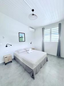 a white bedroom with a large bed and a ceiling at Villa Bèl Ti Vue Piscine Vue Mer et Montagne Pelée in Le Carbet +25 photos