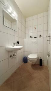 a white bathroom with a toilet and a sink at Best Stay Montreux in Montreux