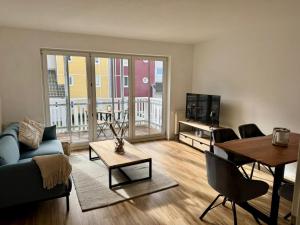 a living room with a couch and a table at Design City Apartment Casper am Yachthafen in Greifswald