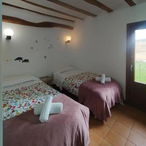 a room with two beds and a window at Casa de los deseos in Villambístia