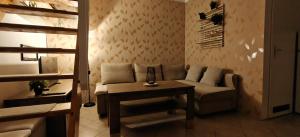 a living room with a couch and a table at Apartmán v Královském Údolí s předzahrádkou in Králŭv Dvŭr