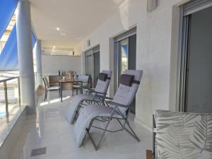 a living room with chairs and a dining room at Apartment with stunning views of Bahia Hornillo & Pool - Aguilas in Águilas