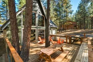Black Butte RanchにあるSpring Home 6 - Cozy 4BR Cabin in Black Butte Ranch w Fireplaceの木製のデッキと木々のある森の中の小屋