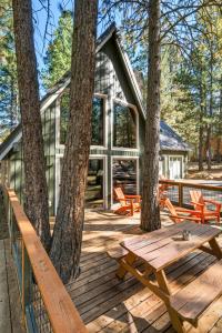 Black Butte RanchにあるSpring Home 6 - Cozy 4BR Cabin in Black Butte Ranch w Fireplaceの木製デッキ(ピクニックテーブル付)