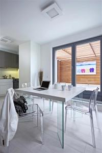 a white dining room table with a laptop on it at Modern Home 