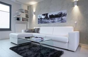 a white living room with a white couch and a glass table at Modern Home 