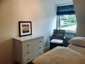 Un dormitorio con una cama y una cómoda y una ventana. en Rivera Hill, en Båstad 4 fotos más
