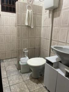 a bathroom with a toilet and a sink at Via sol casa I in Rio das Ostras