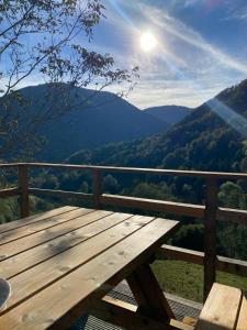 una mesa de picnic de madera en un balcón con vistas a las montañas en Chalet typique des Pyrénées, en Boutx